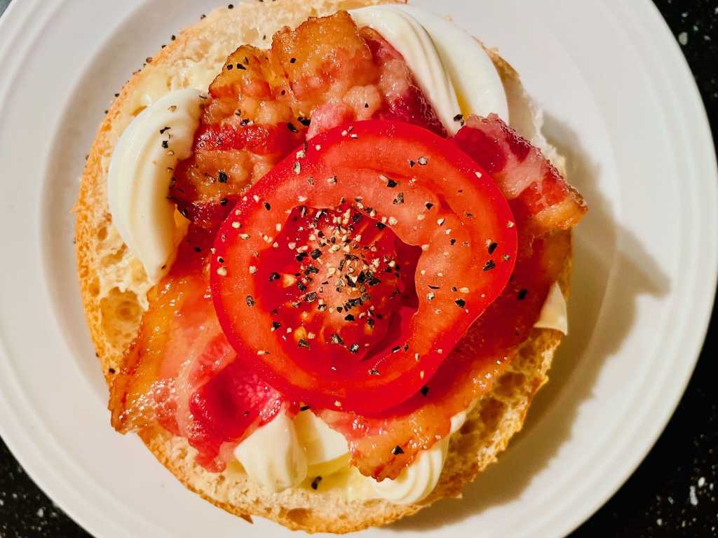 Ägg, bacon och tomat på en fralla.