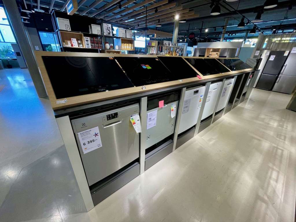 Utsikt över en rad diskmaskiner i en butik, med prislappar och utställning av olika modeller.